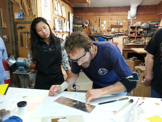 David demonstrating application of gold leaf to sample board.