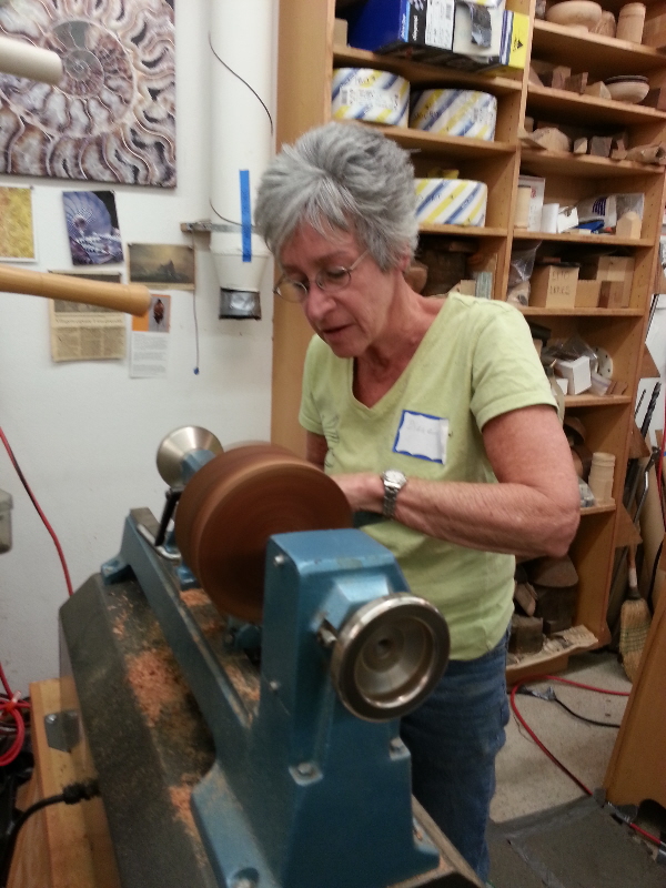 Student working on black acacia bowl